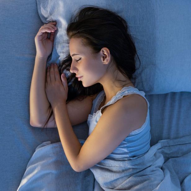 Frau schläft im Bett.