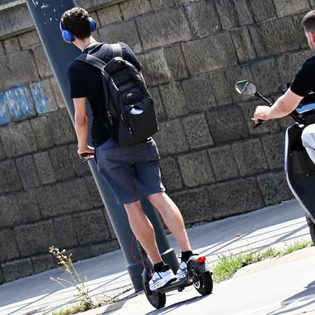 Zwei Personen fahren mit E-Scooter und E-Moped auf der Straße.