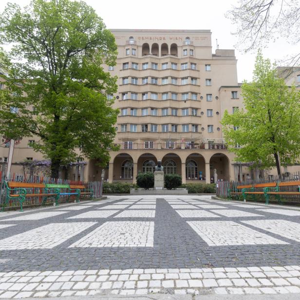 Der Karl-Marx-Hof, ein Gemeindebau in Wien, mit einem gepflasterten Platz im Vordergrund.