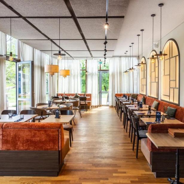 Ein elegantes Restaurant mit Tischen und Stühlen, bereit für Gäste.