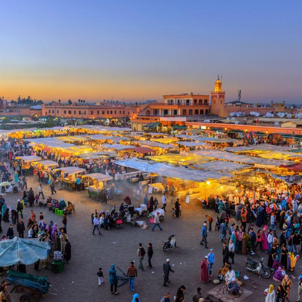 Der Djemaa El Fna-Platz mit der Koutoubia-Moschee in Marrakesch, Marokko, am Abend.