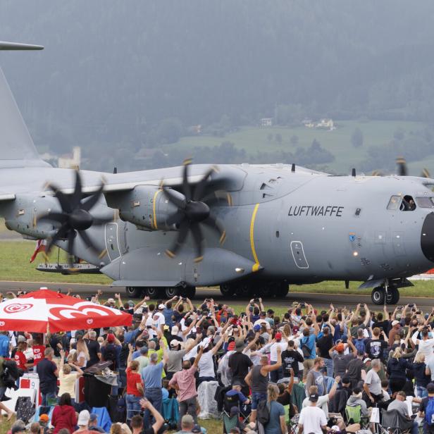 Großes graues Luftwaffe-Transportflugzeug rollt an einer jubelnden Menschenmenge vorbei.