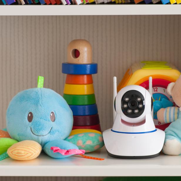 Eine IP-Kamera steht als Babyphone neben Spielzeugen im Regal.