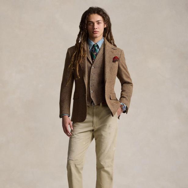 Ein Mann mit Dreadlocks trägt ein Tweed-Sakko und eine passende Weste.