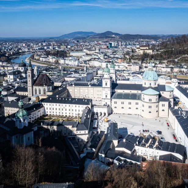 Die Salzburger Altstadt mit Dom und Festung Hohensalzburg erstreckt sich unter blauem Himmel.