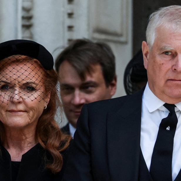 Sarah Ferguson und Prinz Andrew, beide in Trauerkleidung, stehen vor einem Gebäude.