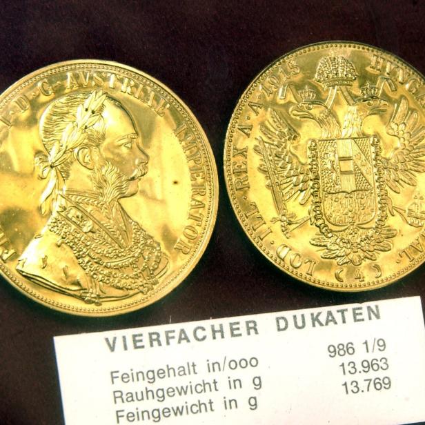 Zwei goldene Dukaten zeigen ein Herrscherporträt und einen Doppeladler mit Wappen, darunter Angaben zu Feingehalt und Gewicht.