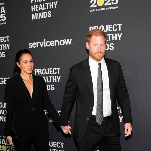 Meghan und Prinz Harry Hand in Hand vor dunklem Hintergrund mit Schriftzügen.