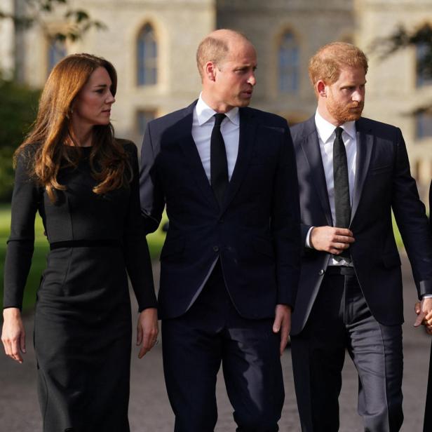 William, Kate, Harry und Meghan gehen zusammen, alle in Schwarz gekleidet.