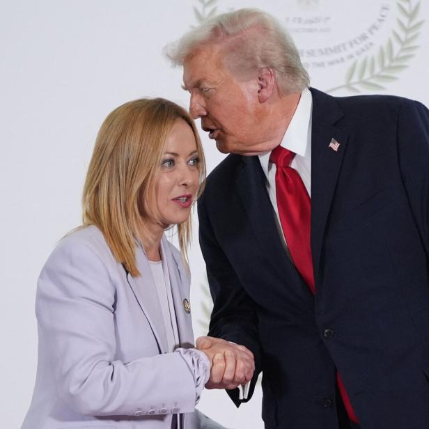 Donald Trump flüstert Giorgia Meloni etwas ins Ohr.