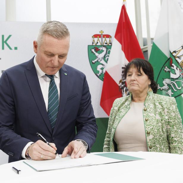 Mario Kunasek und Manuela Khom stehen an Tisch