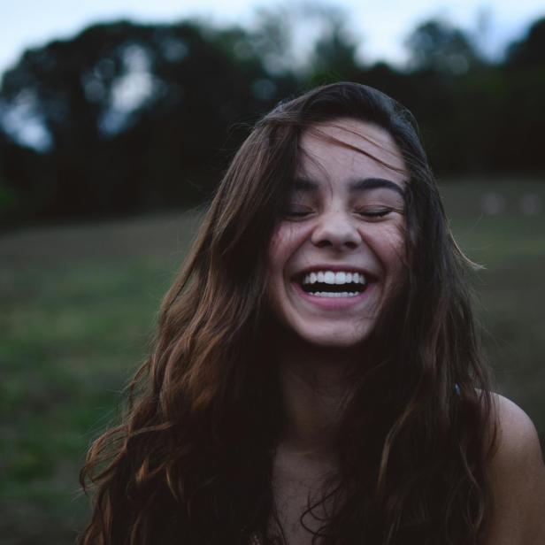 Eine Jugendliche lächelt und zeigt ihre schönen Zähne. 