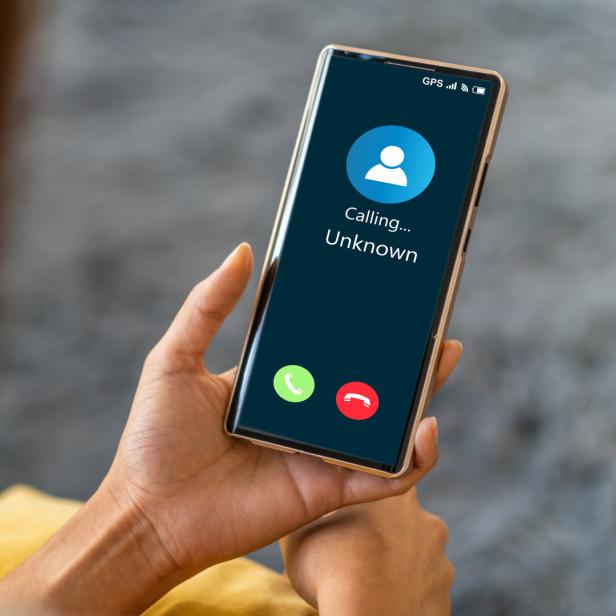 Frau hält Handy mit einkommenden Anruf in der Hand