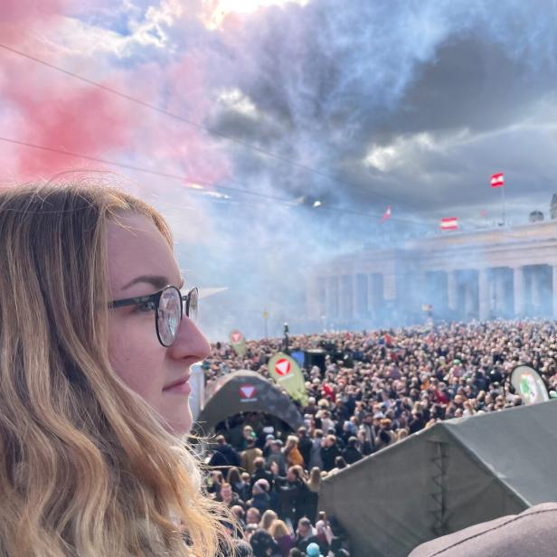 Eine junge Frau beobachtet die Parade auf dem Heldenplatz.