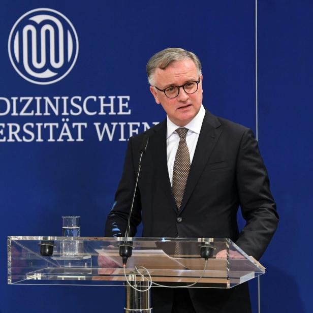 MedUni-Rektor Markus Müller spricht am Rednerpult vor dem Logo der Medizinischen Universität Wien.