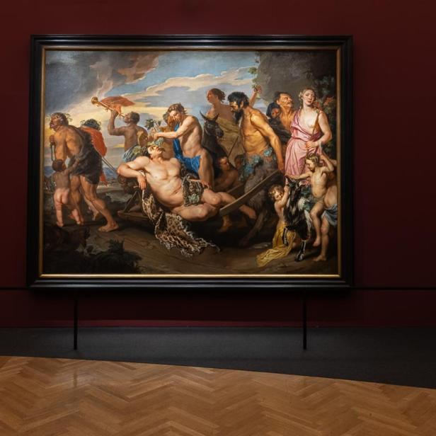 Großes Gemälde mit mehreren Figuren an einer dunkelroten Wand in einem Museumssaal.