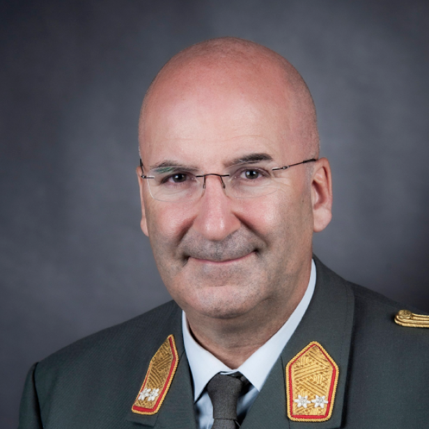 Ein weißer Mann mit Glatze im Bundesheer-Anzug mit Auszeichnungen