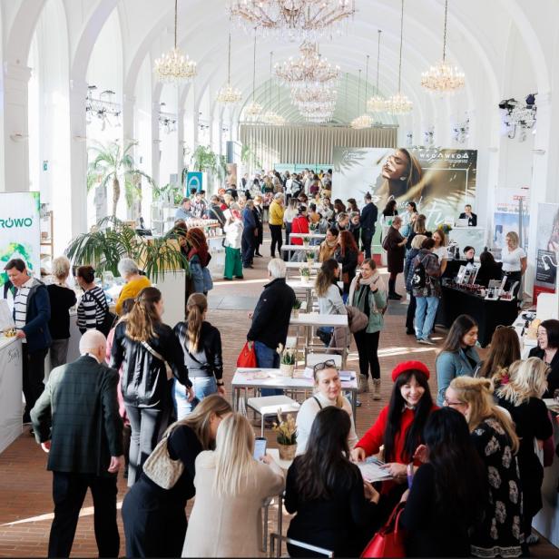 Eine große Gruppe von Menschen in einem weitläufigen Saal.