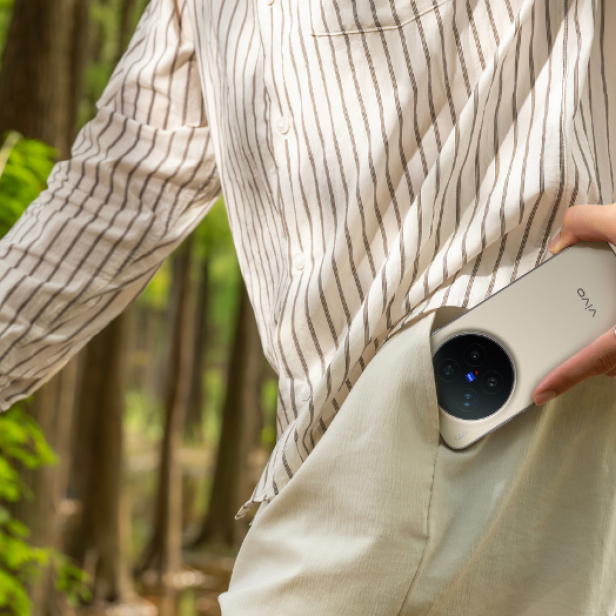 Ein Mann geht und steckt sein Handy in die Hosentasche.