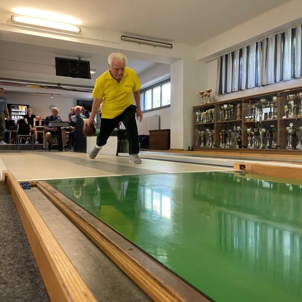 Bruno Wohlmuth im gelben Trikot scheibt eine Kugel auf der Kegelbahn.