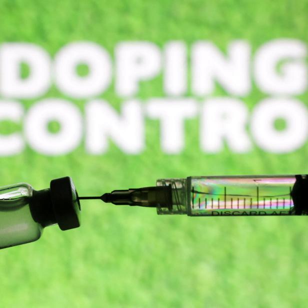 Eine Spritze ist vor dem Schriftzug "Doping Control" zu sehen.