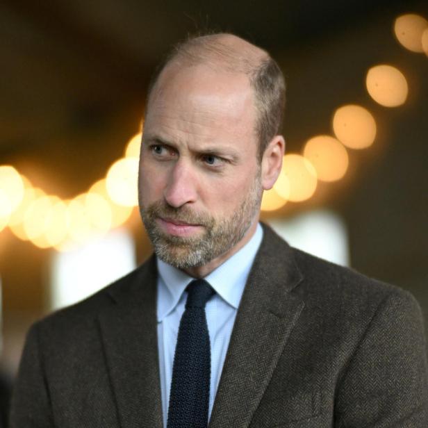 Prinz William mit Bart und Anzug blickt nach links.