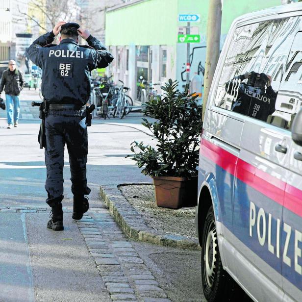 Polizist neben Polizeiauto