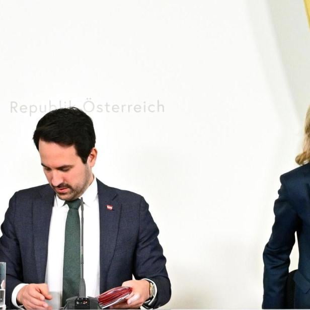 Claudia Plakolm, Christoph Wiederkehr und Michaela Schmidt sitzen nach der Ministerratssitzung gemeinsam am Tisch vor dem österreichischen Bundesadler.