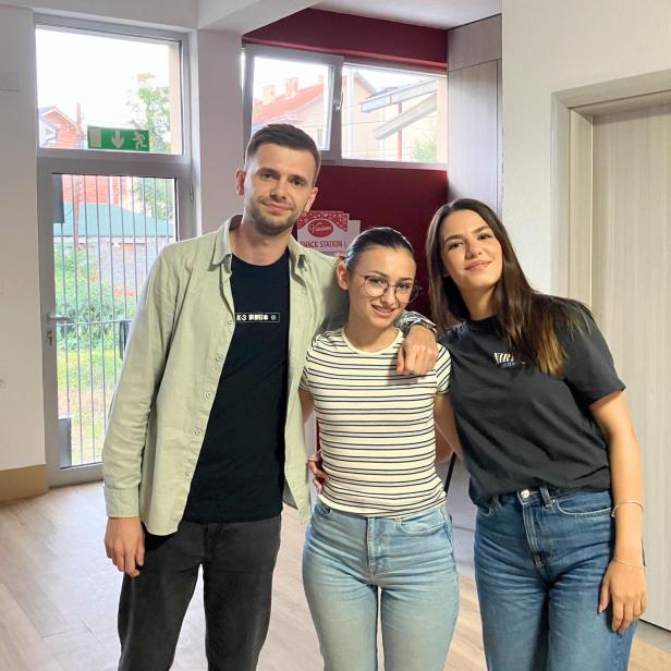 Drei junge Menschen stehen in der Mitte eines Raumes in ihrem Jugendzentrum.