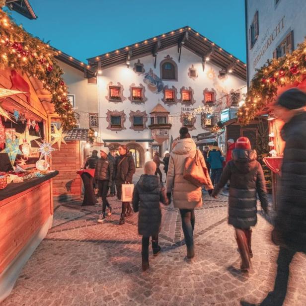 Beleuchtete Stände eines Weihnachtsmarktes in der Kitzbüheler Innenstadt.