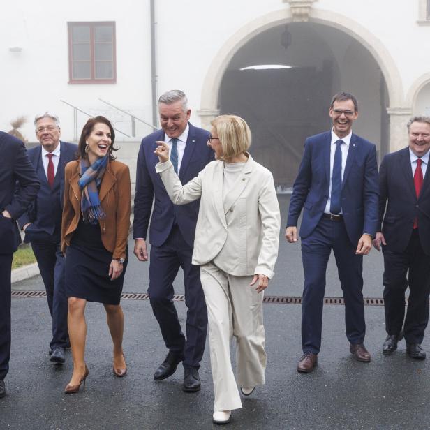 Mehrere Männer und Frauen gegen nebeneinander, im Hintergrund ein Schloss