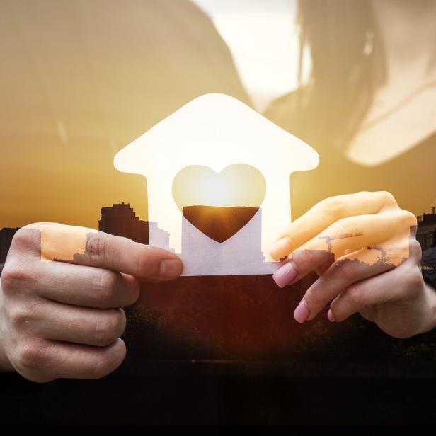 Paar hält das gemeinsame Haus in Händen.