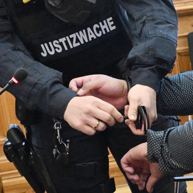 Justizwachebeamter legt Häftling Handschellen an