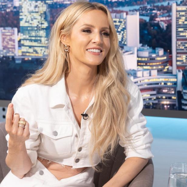 Frau sitzend mit blonden Haaren und weißem Gewand