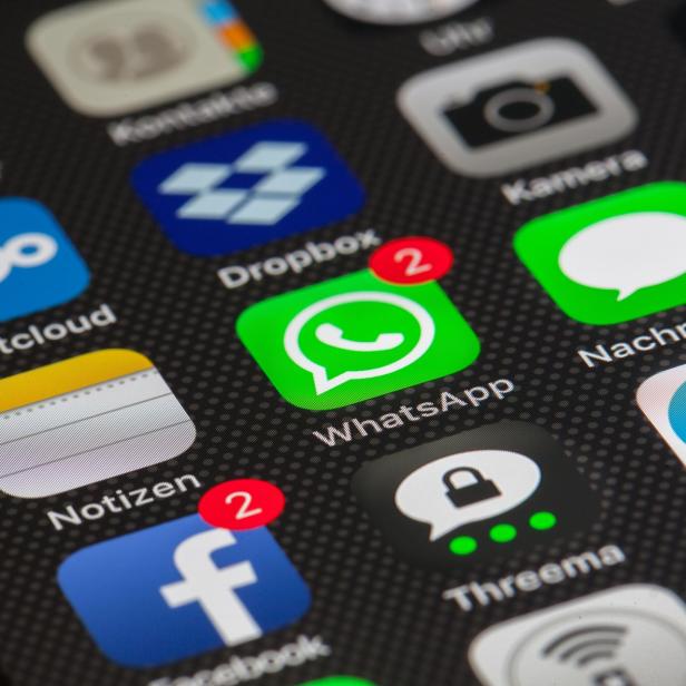 Mehrere bekannte App-Symbole wie WhatsApp, Facebook, Telegram und Dropbox sind auf einem Smartphone-Display zu sehen.