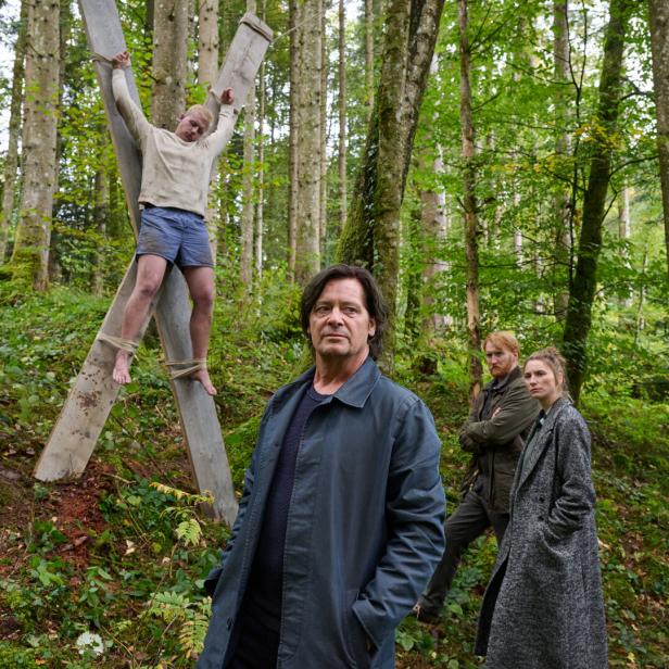 Fritz Karl und Lisa Schützenberger stehen in der Krimi-Folge "Tod am See" vor einem Kreuz, auf dem ein Mann hängt