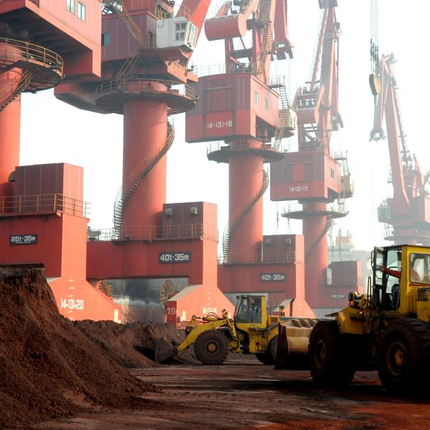 FILE PHOTO: Workers transport soil containing rare earth elements for export at a port in Lianyungang