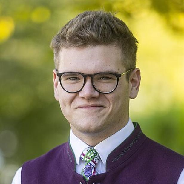 Junger Mann mit Gilet, Krawatte und Brille