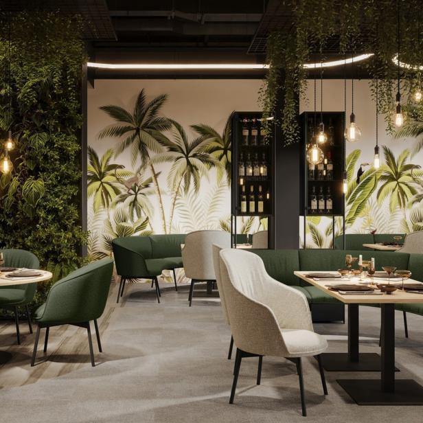 Modern gestalteter Aufenthaltsbereich mit grünen Pflanzen, gemütlichen Sitzmöbeln und Hängelampen.