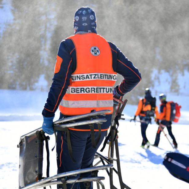 Mehrere Bergretter mit orangefarbenen Warnwesten