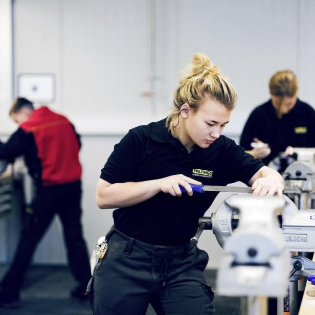Eine Frau arbeitet an einem Werktisch.