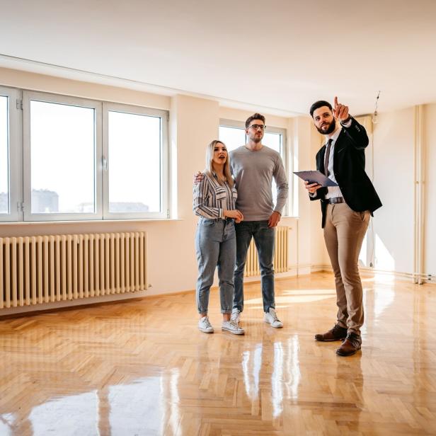 Real estate agent showing an apartment for sale to a young couple