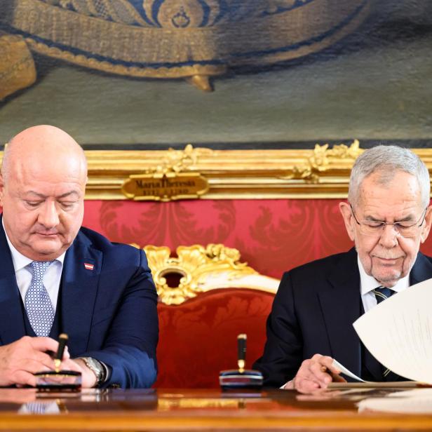 Christian Stocker und Alexander Van der Bellen sitzen an einem Tisch vor einem Gemälde.