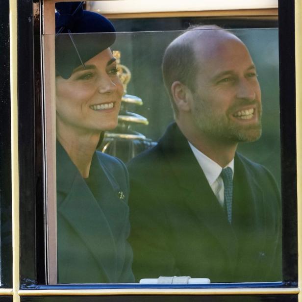 Kate und William lächeln aus dem Fenster einer Kutsche.