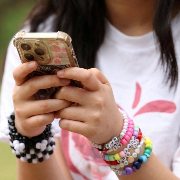 FILE PHOTO: Teens discuss Australia's social media ban for under-16s, set to take effect December 10, in Sydney