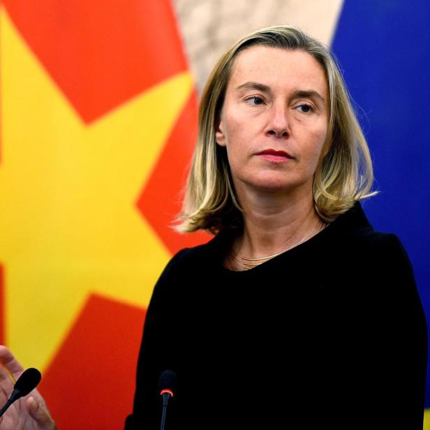Mogherini steht vor den Flaggen Vietnams und der Europäischen Union und spricht an einem Mikrofon.