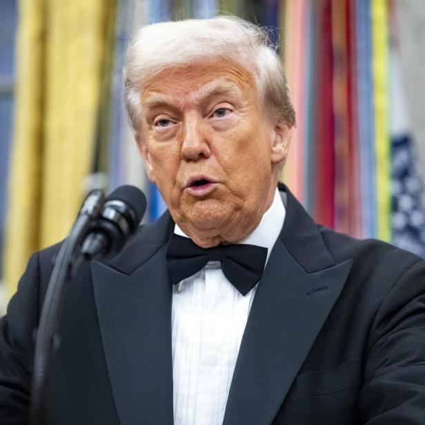 Donald Trump spricht in einem Smoking vor einem Mikrofon.