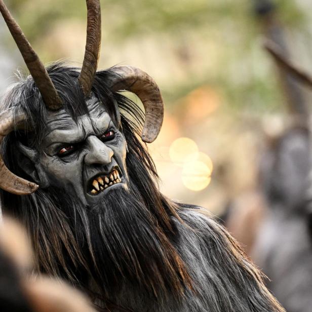 Eine gruselige Krampus-Maske mit Hörnern, Fell und fletschenden Zähnen ist zu sehen.