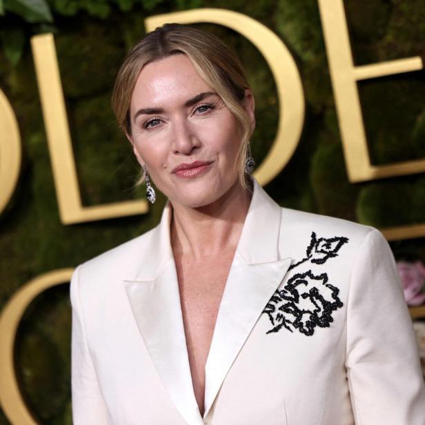 Kate Winslet trägt einen weißen Blazer mit schwarzer Blumenapplikation.