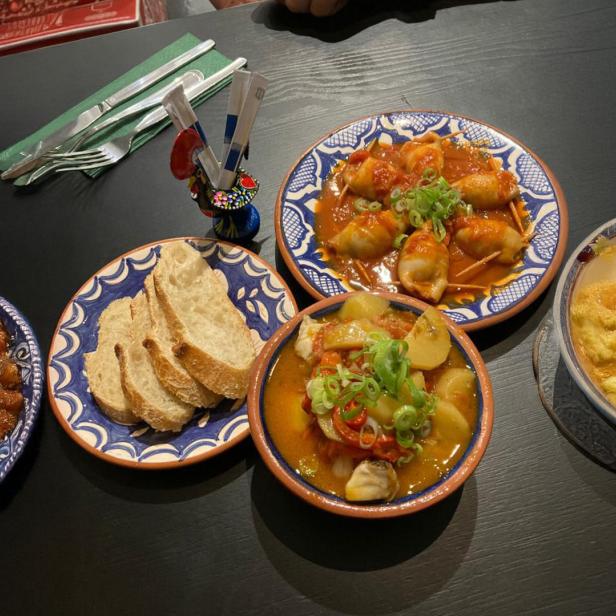 Teller mit Essen auf einem schwarzen Tisch 